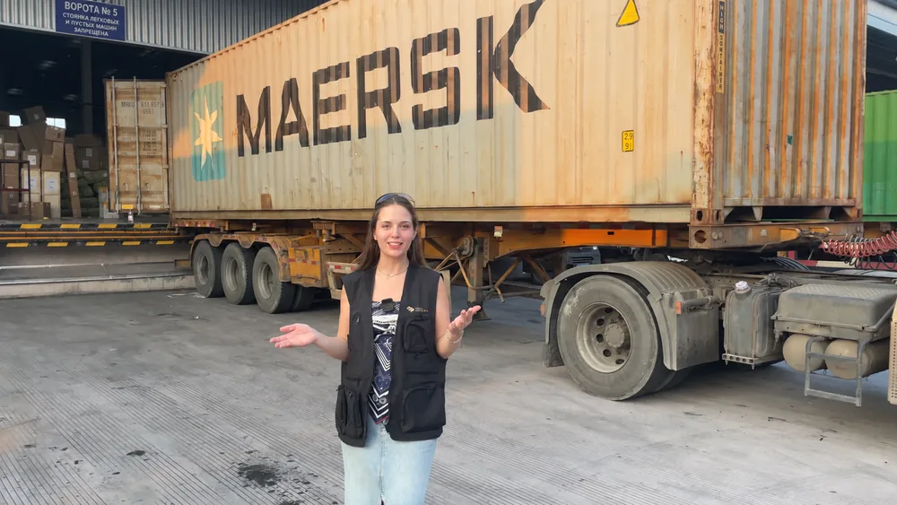 Сотрудница Tiger Logistics рядом с контейнеровозом на складской погрузочной площадке